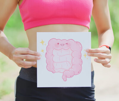 Frau hält sich die Zeichnung eines glücklichen Darms vor den Bauch